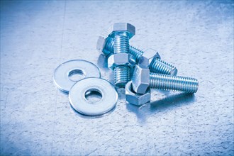 Metal threaded screws Nuts and bolts Washers on metallic background Construction concept