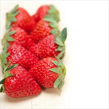 Fresh organic strawberry over white rustic wood table