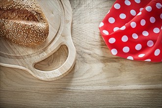 Bread carving board red polka-dot tablecloth on wooden background
