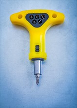 Insulated electric yellow screwdriver on metallic background Design concept