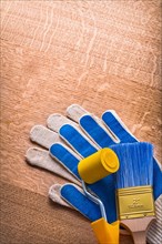 Painting brush with protective gloves on wooden panel Maintenance concept