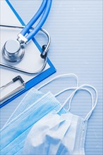 Masks clipboard stethoscope on blue background medical concept