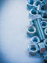 Threaded nuts and bolts on a metallic background Design concept