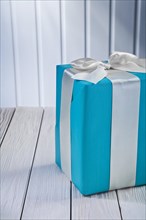 Blue gift box with bow on a white wooden table