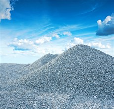 Pile of granite gravel on the background of the sky