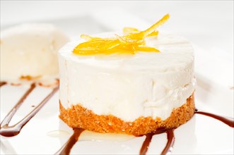 Very elegant lemon mousse dessert served whith lemon peel on top and vanilla ice cream on side