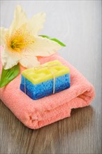 Bath sponge soap and flower on towel