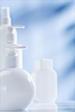 Composition of white skin care products on a blue background