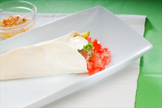 Fresh traditional falafel wrap on pita bread with fresh chopped tomatoes