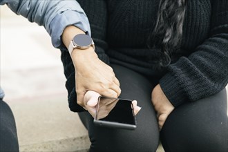 Two Spanish-Latino women with smartphones and smartwatches