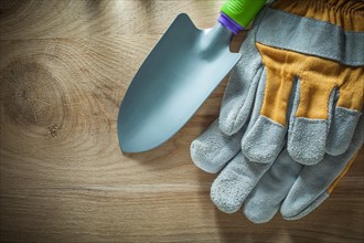 Gardening hand spade safety gloves on wooden board