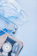 Stethoscope with blood pressure monitor and masks on a blue background medical concept