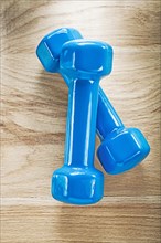 Blue dumbbells on wooden board sports training concept