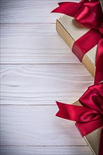 Gift-containers with tied ribbons on wooden board holidays concept