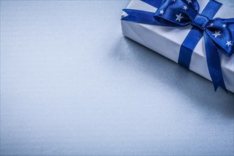 Giftbox with present ribbon on blue background holidays concept
