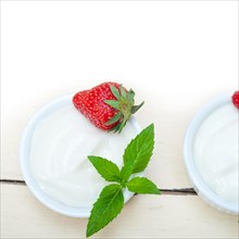 Organic Greek yogurt and strawberry over white rustic wood table