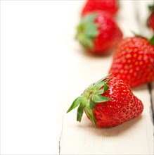 Fresh organic strawberry over white rustic wood table