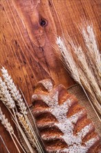 Bread and ears of wheat on a vintage wooden board Food and drink concept