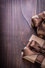 Copyspace image two vintage gift boxes covered crumpled paper with brown ribbon on old wooden board holiday concept