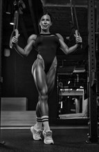 Black and white image of a sexy fitness woman. A beautiful sportswoman is training in the gym. Mixed media