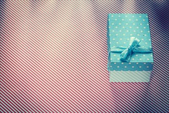 Wrapped present box on red striped textile celebrations concept