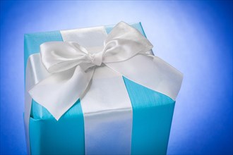 Blue gift box with a white bow on a blue background