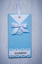 Blue invitation envelope on a grey background