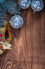 Christmas background mirror disco balls and carnival mask branch of fir tree on old wooden board with copyspace