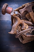 Composition of rusted tools in wicker box on wooden board