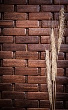 Golden wheat and rye ears on wooden mat vertical version