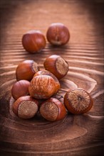 Small pile of hazelnuts on an old wooden board Food and drink Still life