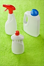 Three white plastic bottles on a green background