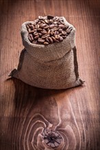 Bag of coffee beans on an old wooden board