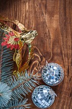 Christmas composition mirror disco balls and fir tree branch with golden carnival mask on old wooden board