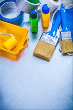 Household tapes protective gloves and set of paint tools on metallic background construction concept