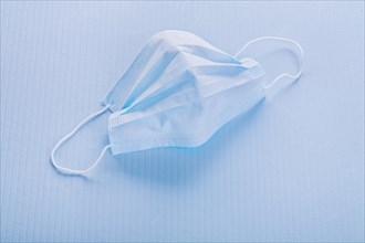 Disposable face mask on a blue background