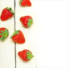 Fresh organic strawberry over white rustic wood table