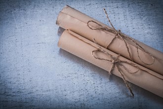 Age-old corded paper rolls on scratched metallic surface