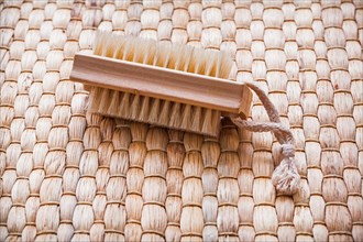 Single wooden scrubbing brush on wicker mat Healthcare concept