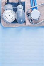 Organised copyspace stethoscope with blood pressure monitor on blue background medical concept