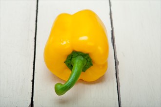 Yellow fresh bell pepper over old wood table