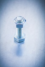 Threaded screw bolt with construction nut on metallic background repairing concept
