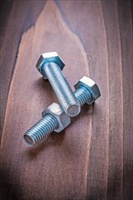 Bolts and nuts on vintage wooden board Construction concept