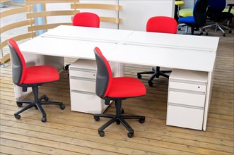 Office desks and red chairs cubicle set view from top over wood flooring