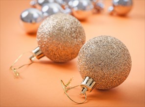 Golden Christmas tree bauble on an abstract light brown background