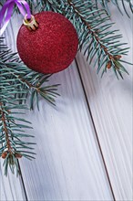 Copyspace image Christmas bauble on white boards and Christmas tree branch