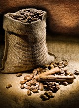 Dark composition of coffee beans and linen bag