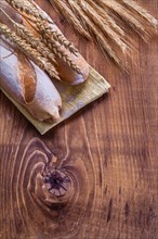 Wheat ears and baguettes on vintage cardboard with copy surface