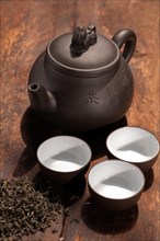Chinese green tea traditional pot and cups over old wood board