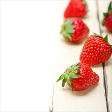 Fresh organic strawberry over white rustic wood table